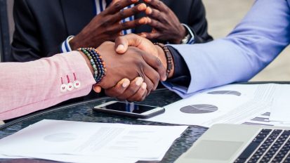 close-up-hands-group-three-stylish-african-american-businessman-friends-handshaking-summer-cafe-outdoors-concept-successful-good-deal_175356-1460